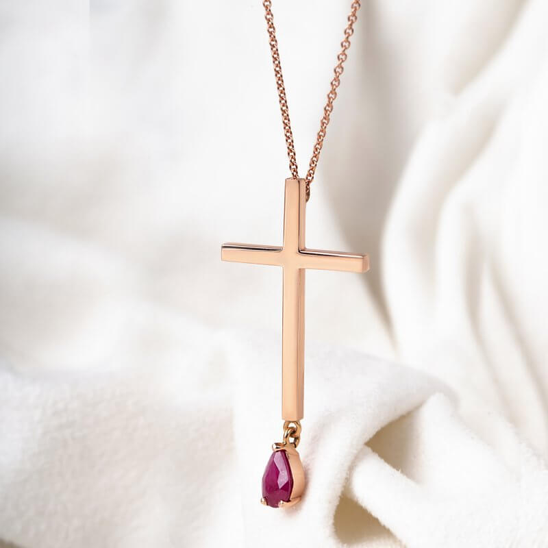 14k rose gold cross with a ruby drop hanging