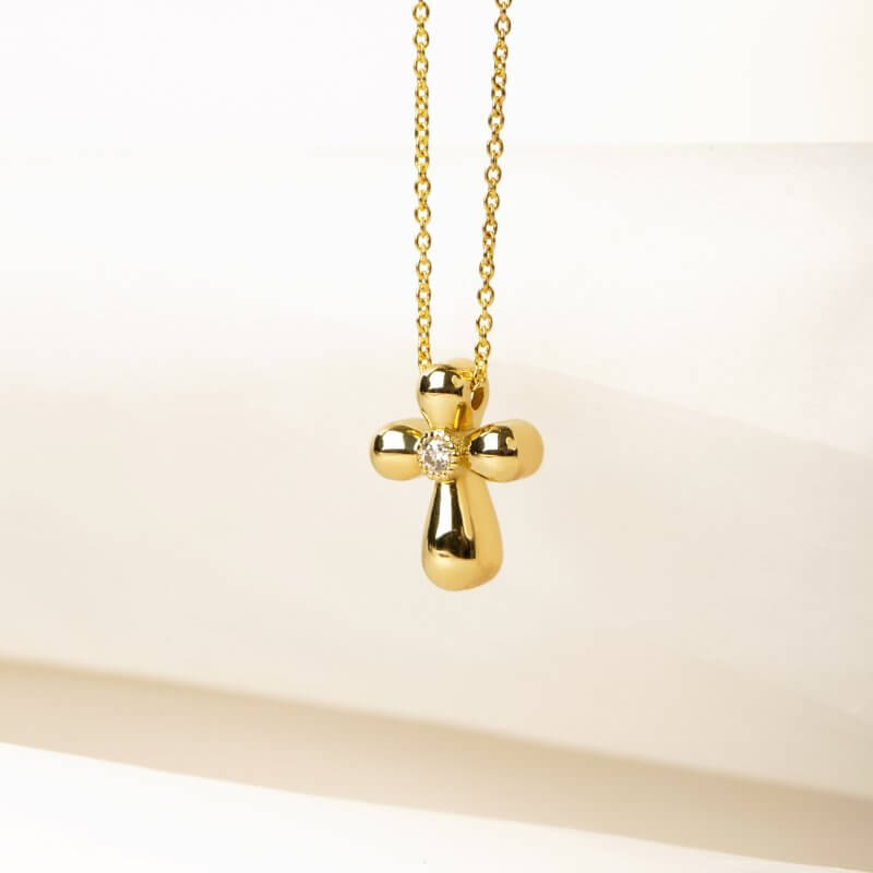 Curved gold cross with a diamond